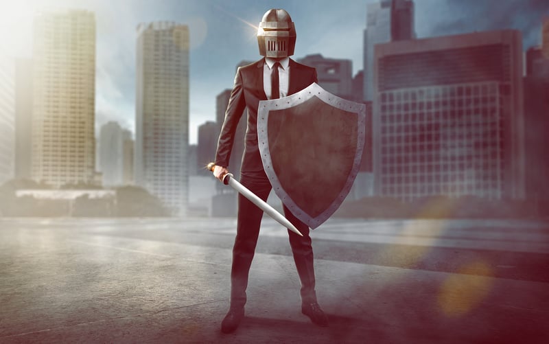 Ein Business Man mit einem Ritterhelm, einem Schild und einem Schwert steht in einer Stadt