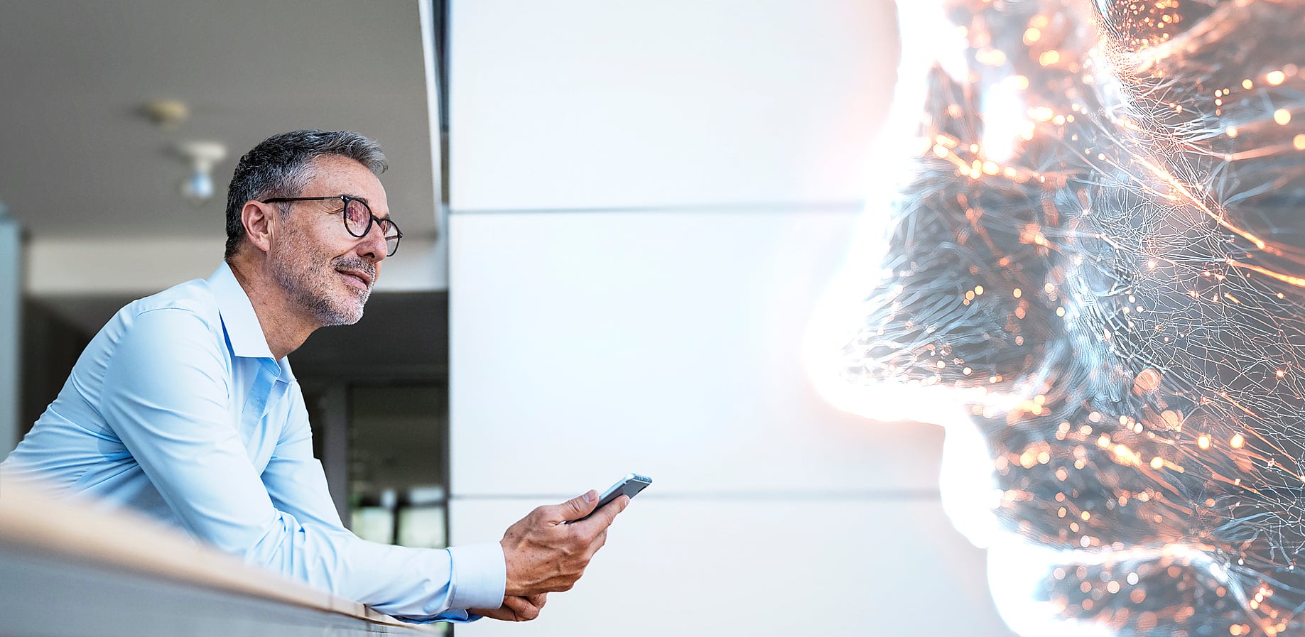 Mann in Büroumgebung mit Smartphone gegenüber KI-Netzwerk in Form eines menschlichen Kopfes